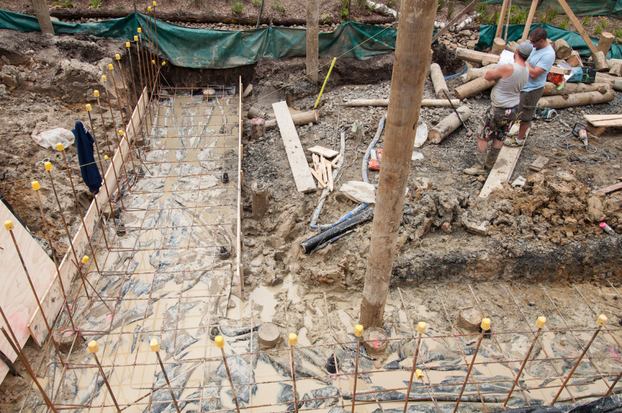 The retaining wall footing area all ready for the concrete to be poured while Ray and Garrick review the plans.
