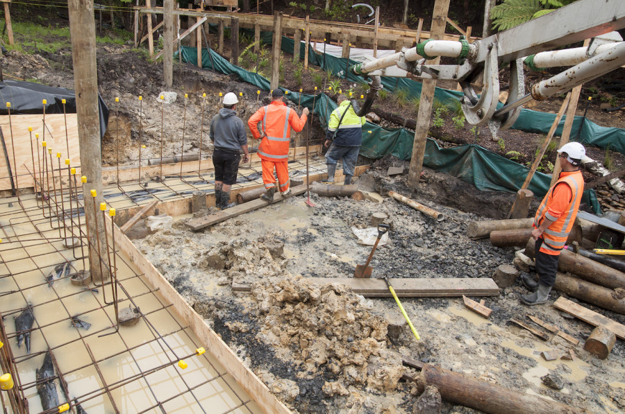 The concrete starting to be poured into the footings for our retaining wall.
