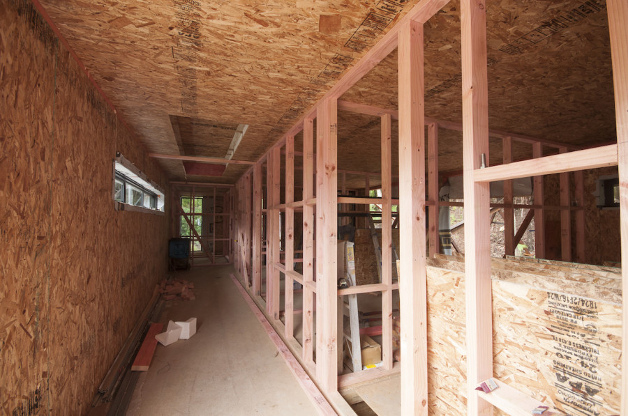 A really wide shot down the hallway. From front to back we have our bathroom, laundry, bedroom 3, bedroom 2 and then our master suite right at the end. I love those narrow windows from Rylock along the side
