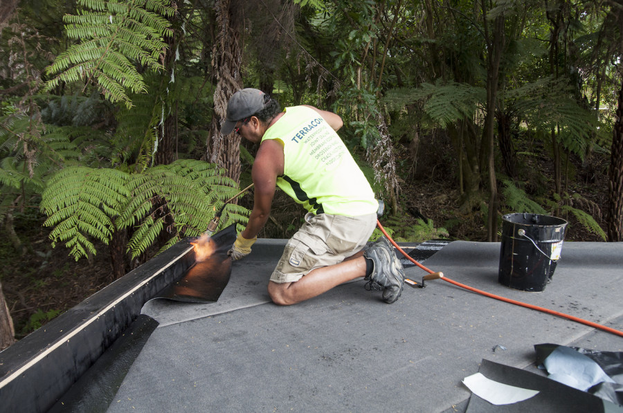 A bit of heat makes the base sheet a little more flexible to fit snuggly over the parapet.