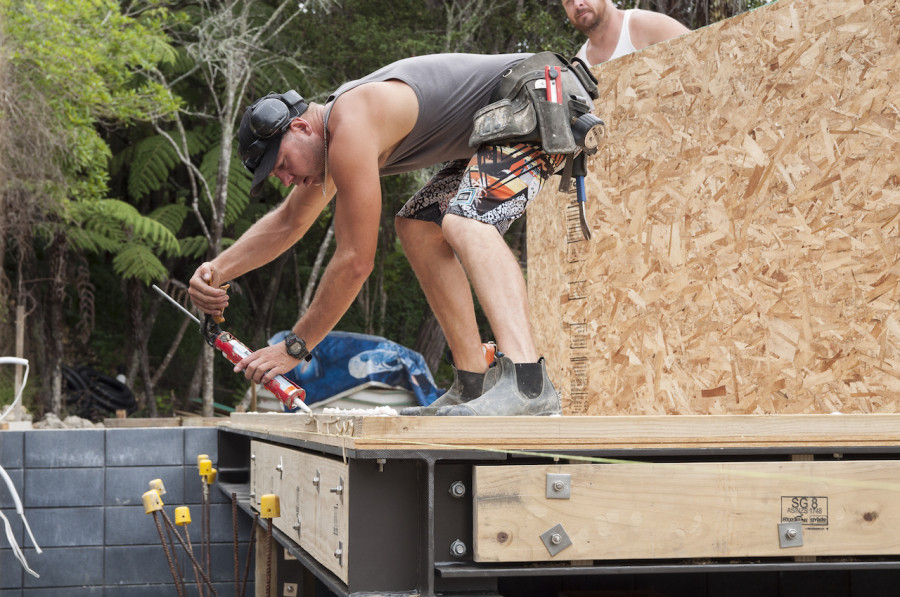 Dan putting down the glue along the bottom plate in preparation for the first panel to be put into place. 