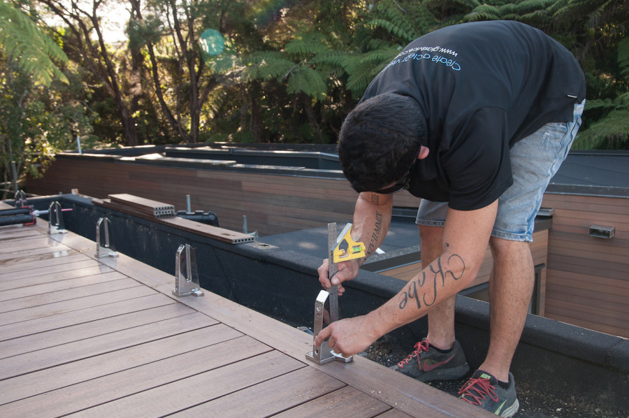 Anthony from Glass Vice installing the top-fixed vices on our floating roof top deck.