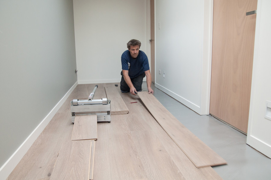 Jason laying the Quick Step laminate in our hallway.