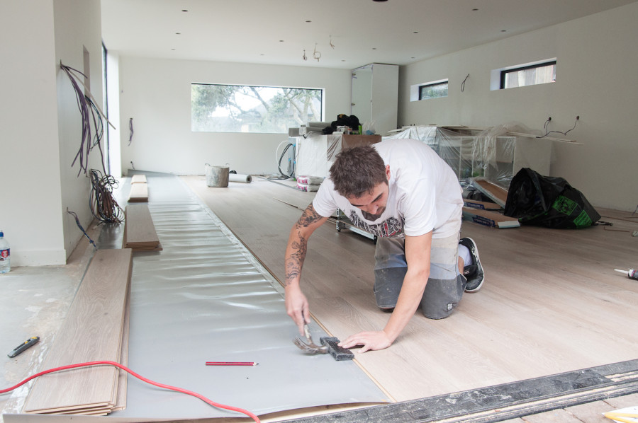 Meanwhile in the living pod John was laying the floor at super speed.